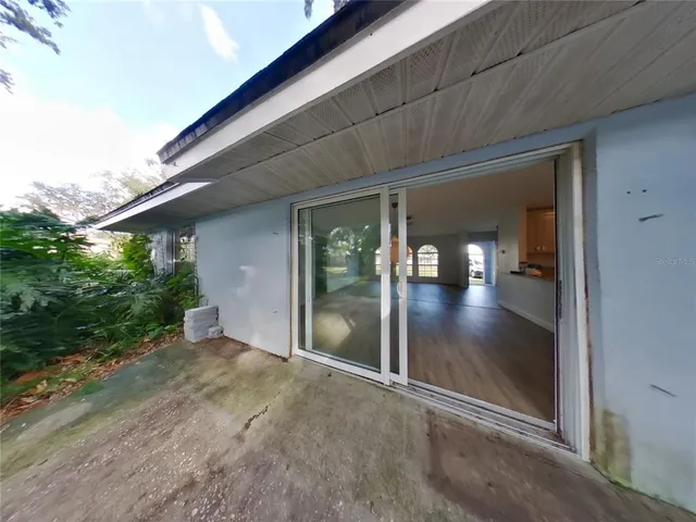 an empty room with sliding door and wooden floor