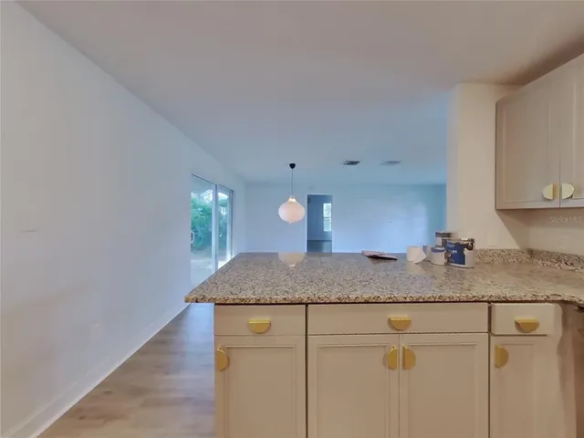 a kitchen with a granite countertop sink and cabinets