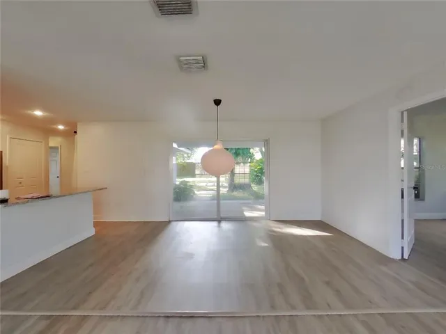 a view of a room with wooden floor potted plant and a ceiling fan