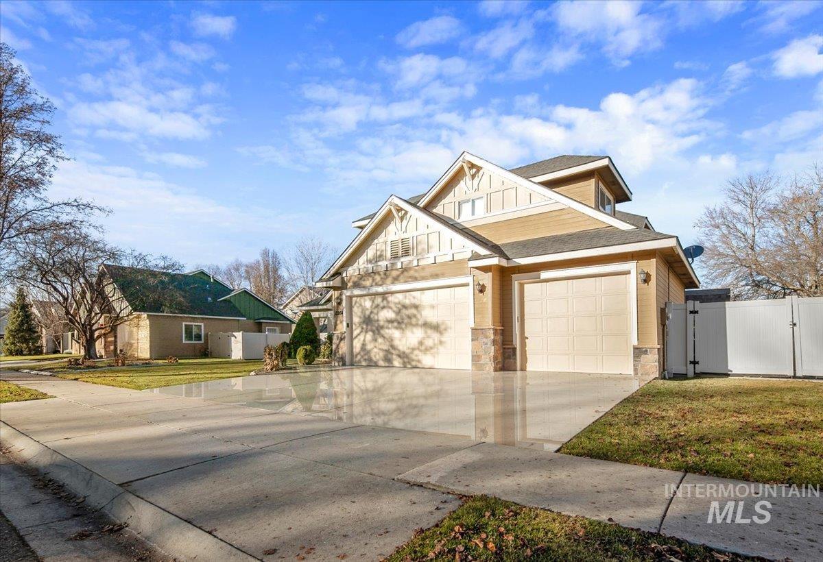 2264 East Comisky Street Meridian, ID 83646 - Photo 4 of 47 Craftsman-style house with a gate, stone siding, driveway, a shingled roof, and an attached garage