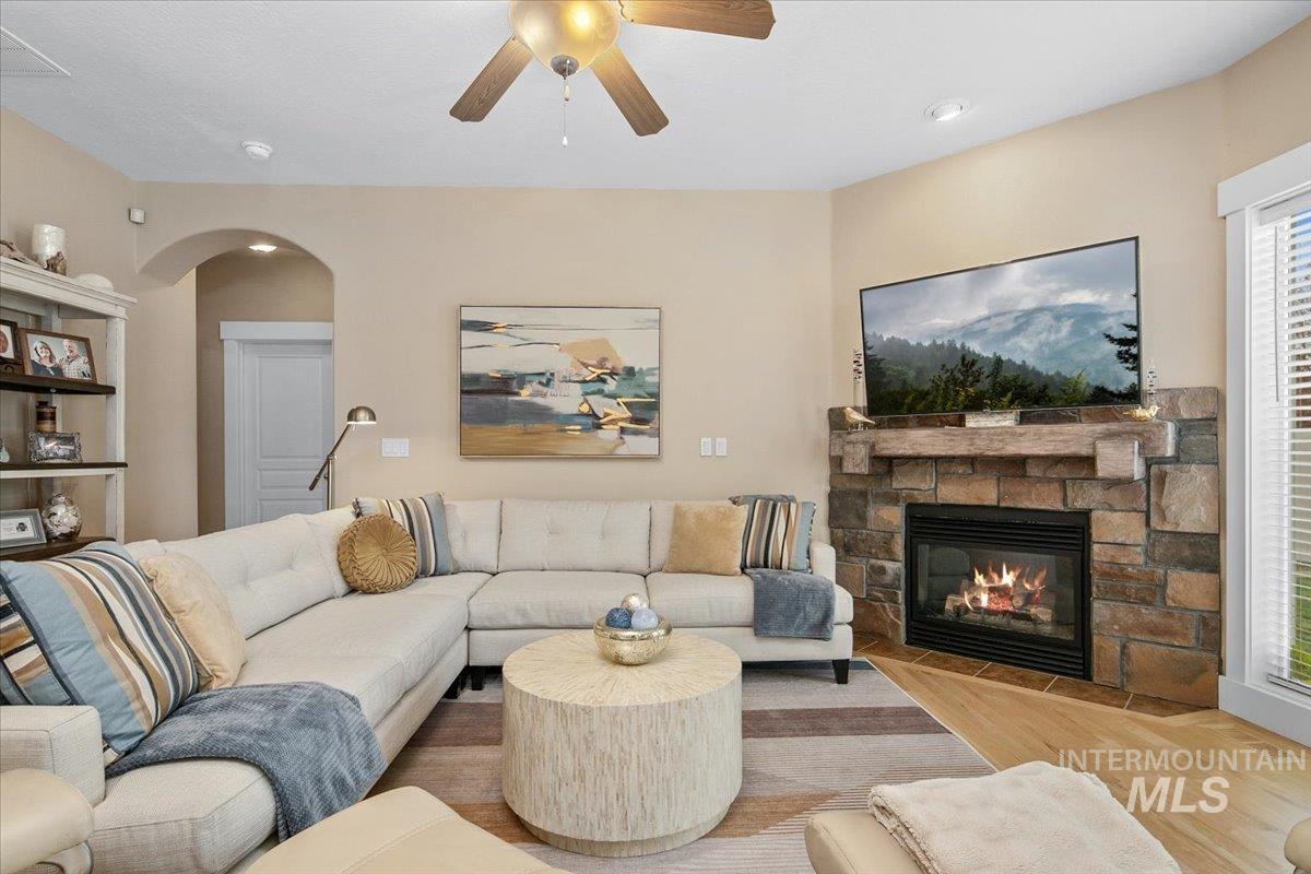 2264 East Comisky Street Meridian, ID 83646 - Photo 8 of 47 Living room with wood finished floors, a fireplace, arched walkways, and ceiling fan