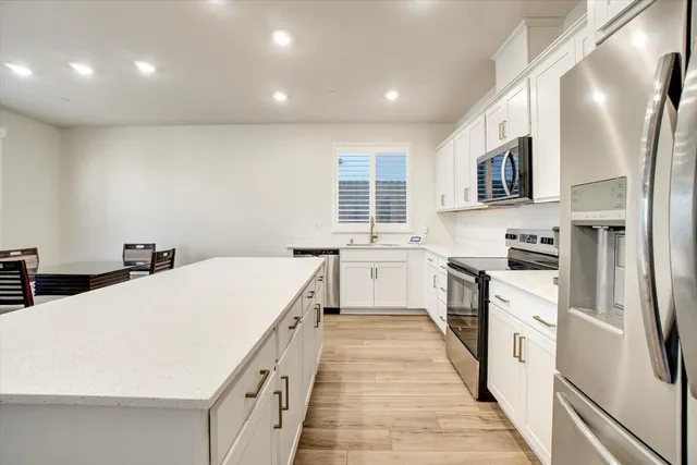 a kitchen with white cabinets and white appliances