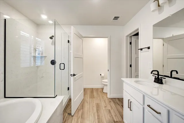 a spacious bathroom with a double vanity sink a mirror a shower and a bathtub