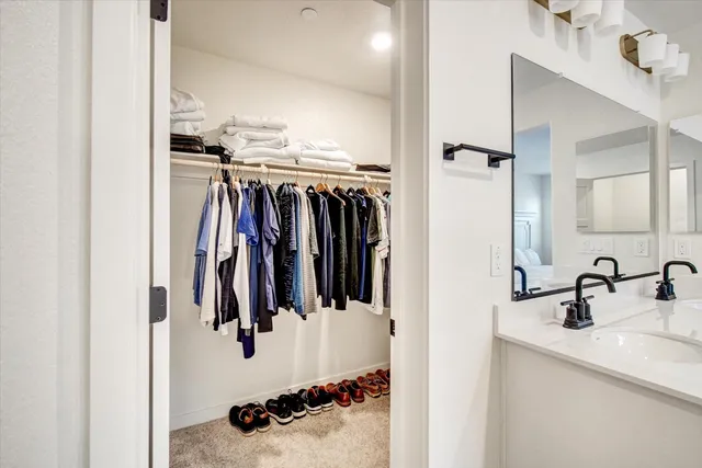 a view of walk in closet with clothes and shoes