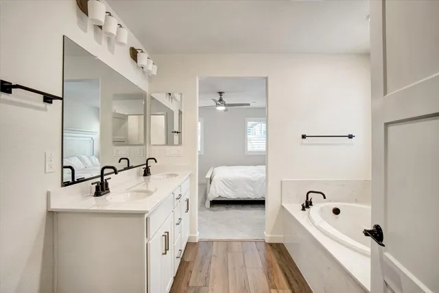 a bathroom with a tub sink and mirror