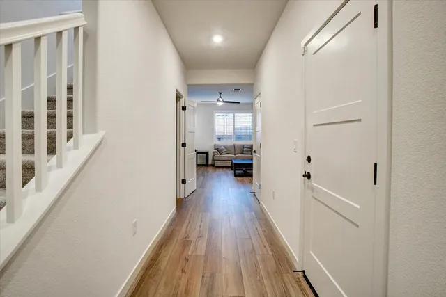 a view of a hallway with wooden floor and staircase