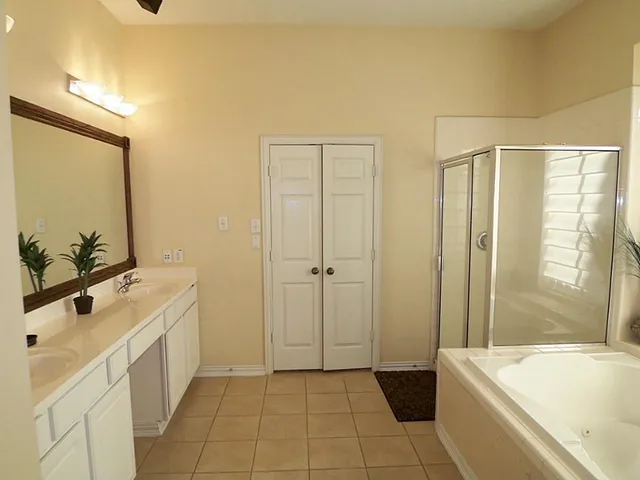 a bathroom with a tub sink and mirror