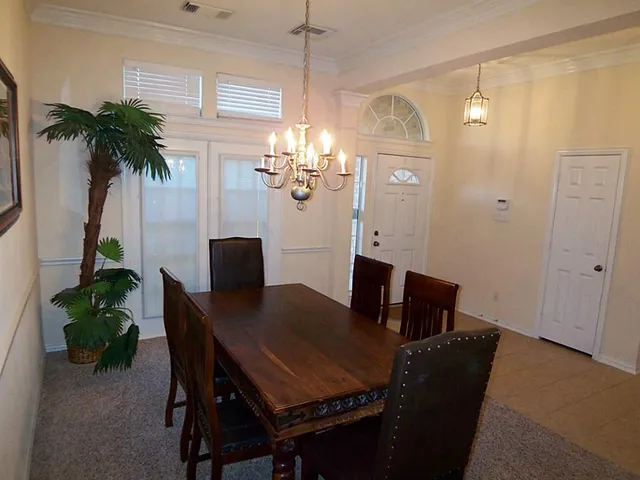 a view of a dining room with furniture and chandelier