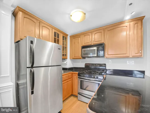 a refrigerator freezer sitting in a kitchen with stainless steel appliances granite countertop cabinets and a refrigerator