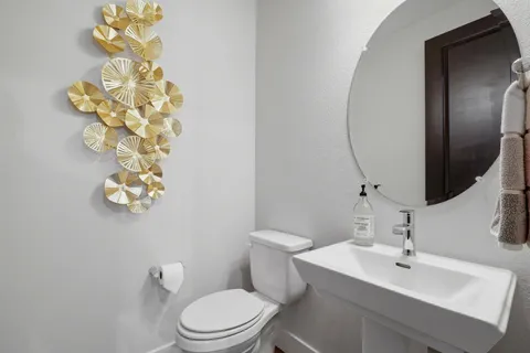 a bathroom with a sink mirror and toilet