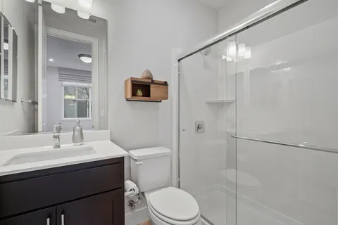 a bathroom with a sink toilet a mirror and shower