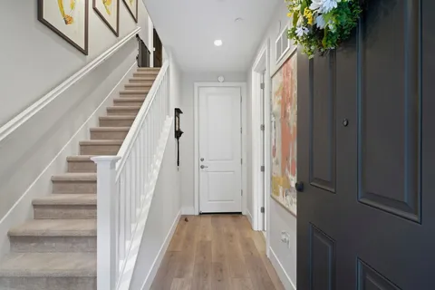 a view of a hallway with wooden floor and stairs