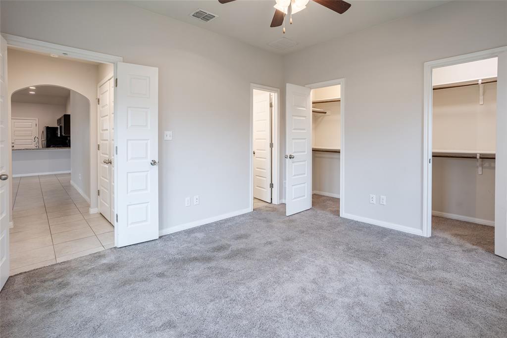 615 Stampede Road San Marcos, TX 78666 - Photo 10 of 26 A versatile room featuring two walk-in closets and direct access to an adjacent kitchen space.