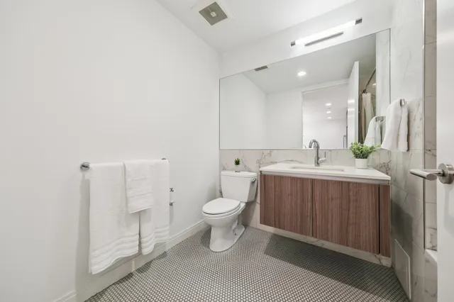a bathroom with a toilet sink and mirror