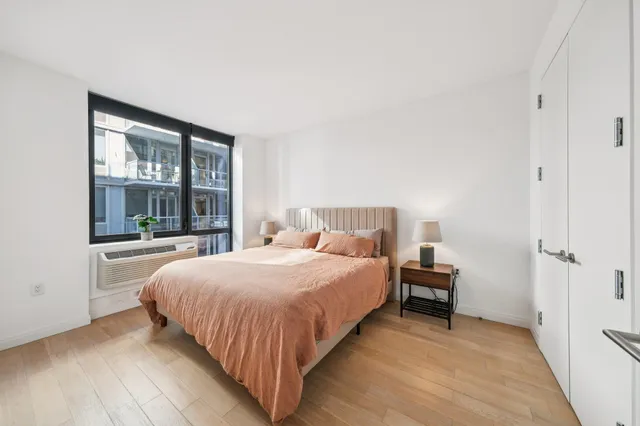 a bedroom with a bed and a large window