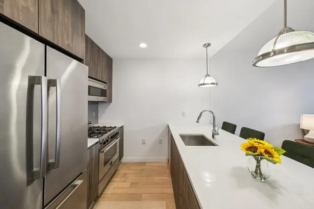 a kitchen with stainless steel appliances granite countertop a sink a stove and a refrigerator