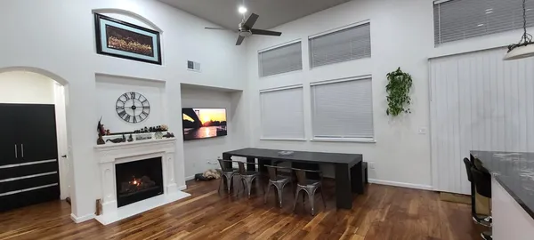 a kitchen with stainless steel appliances granite countertop a stove a refrigerator and a fireplace with wooden floor