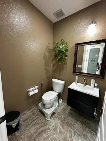 an empty room with wooden floor cabinet and windows