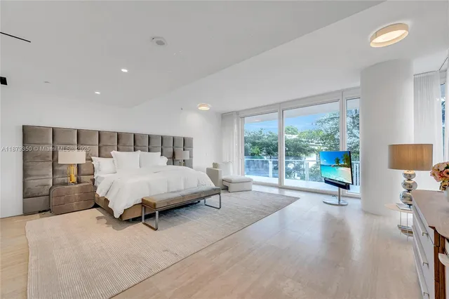 a bedroom with a bed and large window