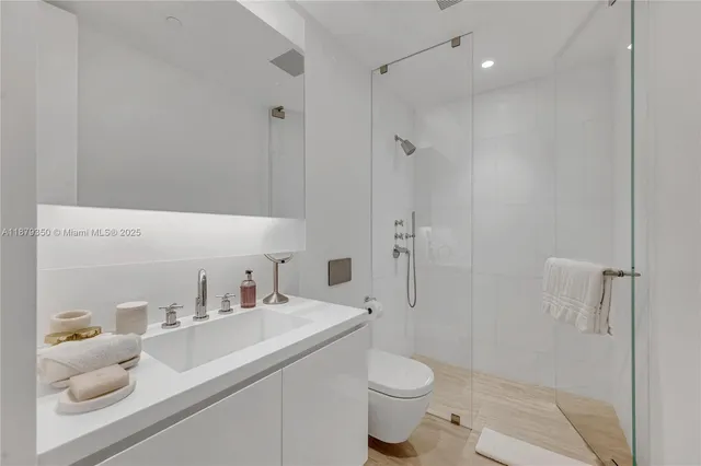 a bathroom with a sink toilet vanity and shower