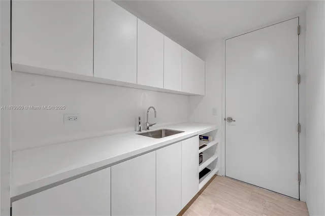a kitchen with stainless steel appliances granite countertop a sink and a white cabinets