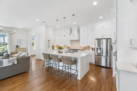 a kitchen with a sink a refrigerator and wooden floor