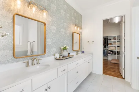 a bathroom with double vanity sinks and a mirror
