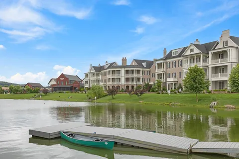 an aerial view of a house with a garden and lake view