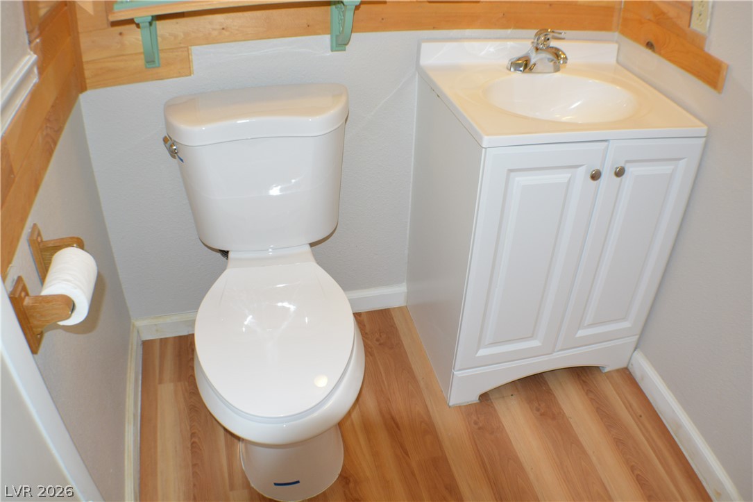 1321 Trout Canyon Road Las Vegas, NV 89124 - Photo 23 of 50 A compact bath features wood flooring and a classic white vanity with a basin sink.