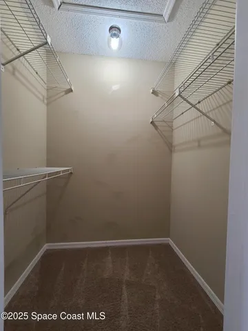 an empty room with a window and a ceiling fan