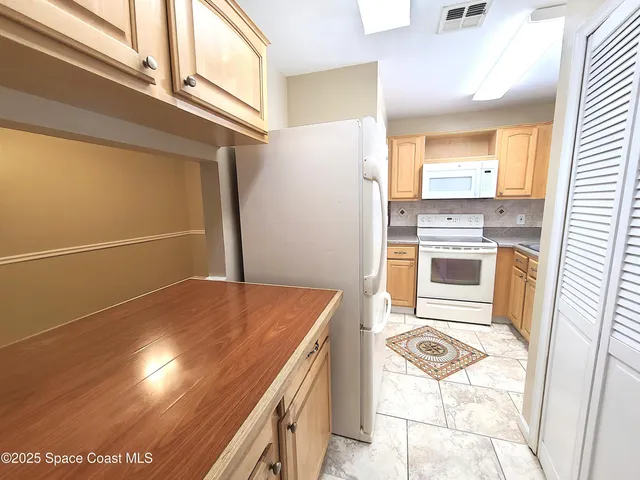 an empty room with windows and chandelier fan