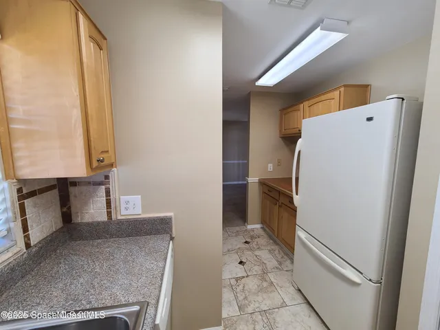 an empty room with windows and chandelier fan