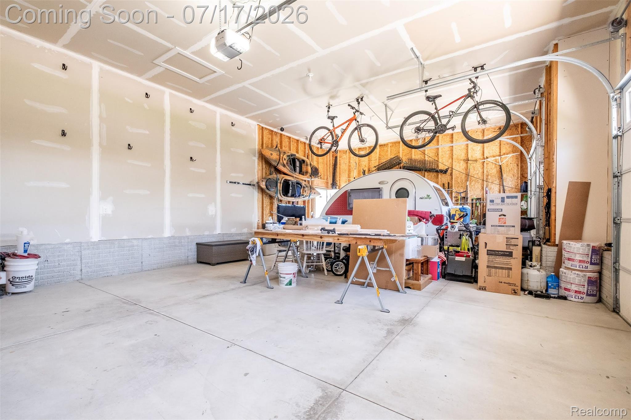 12349 Sugar Maple Drive Fenton, MI 48430 - Photo 49 of 67 Spacious garage featuring a concrete floor, exposed ceiling joists, and a garage door opener system