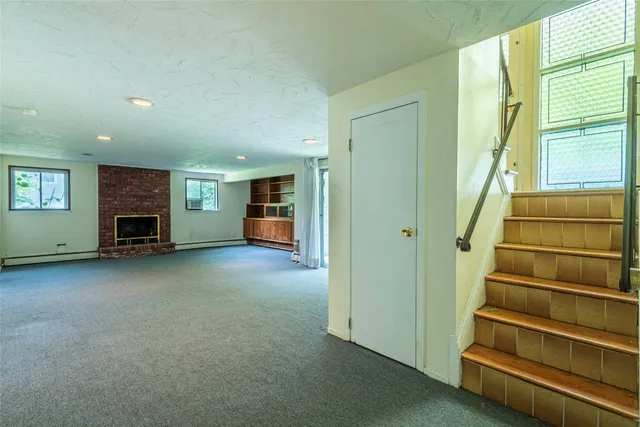 a view of empty room with fireplace and windows
