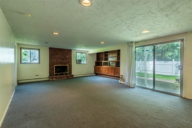 an empty room with fireplace and window