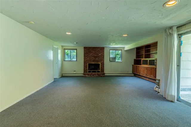 an empty room with a fireplace and window