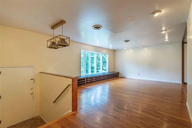 an empty room with windows and ceiling fan