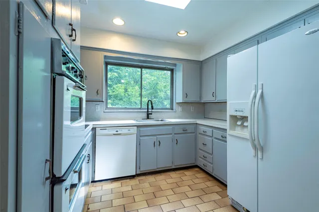 a kitchen with white cabinets and white appliances