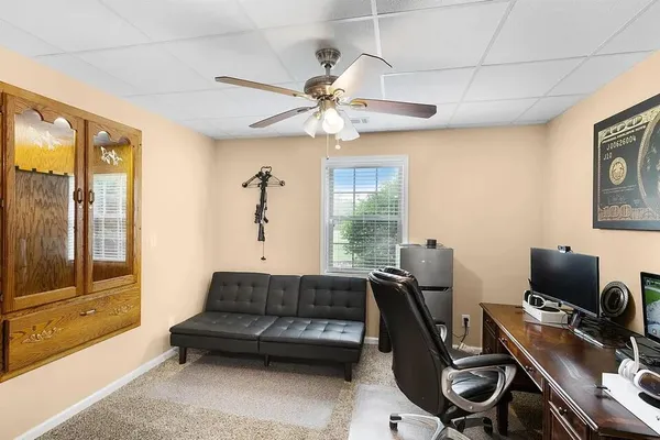 a living room with furniture a ceiling fan and a window