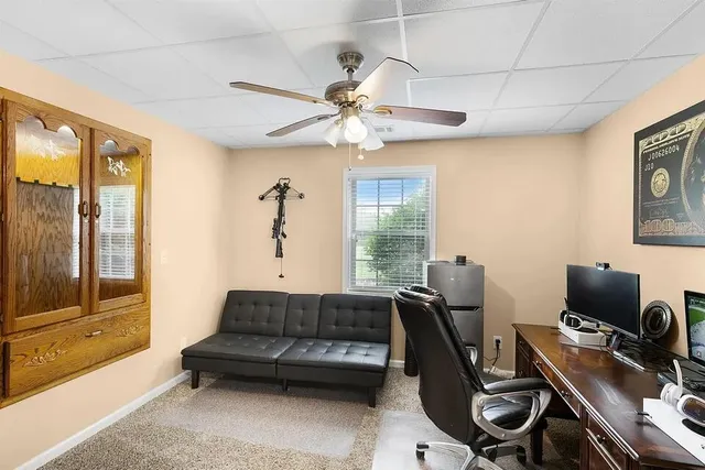 a living room with furniture a ceiling fan and a window