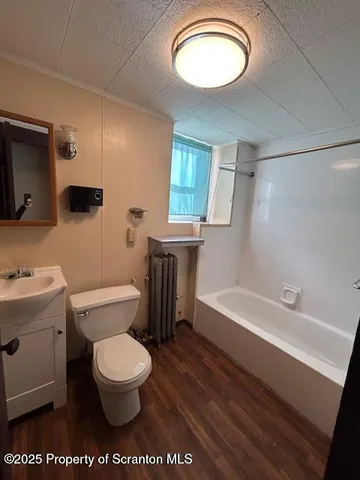 a bathroom with a toilet sink a mirror and shower