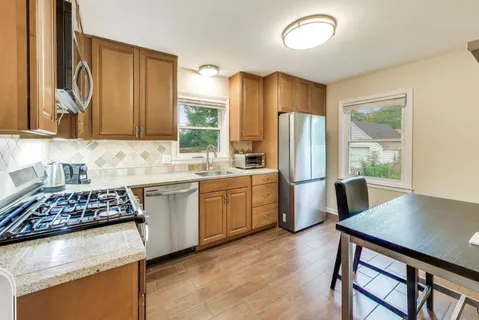 a kitchen with stainless steel appliances granite countertop a stove refrigerator sink and cabinets