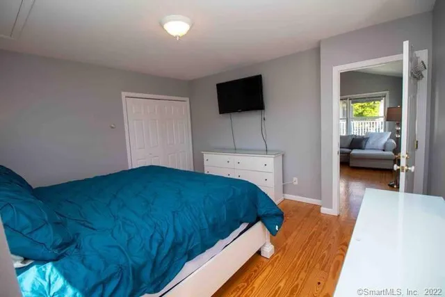 a bedroom with a bed and a flat tv screen on dresser