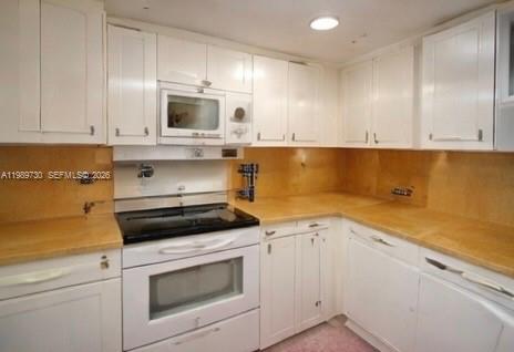 3531 Inverrary Drive, Unit 310 Lauderhill, FL 33319 - Photo 3 of 10 a kitchen with granite countertop a stove a sink and a microwave