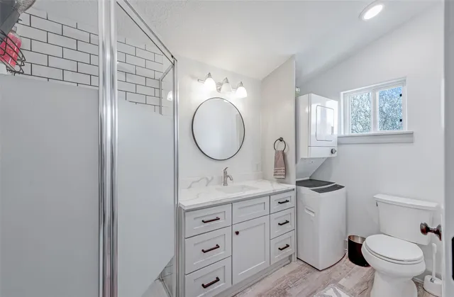 a bathroom with a granite countertop toilet sink and mirror