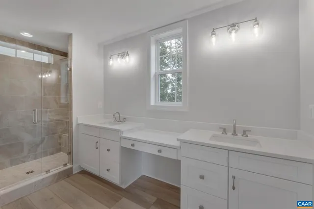 a bathroom with double sink and two mirror