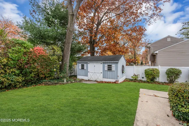 a view of a house with a yard and large tree