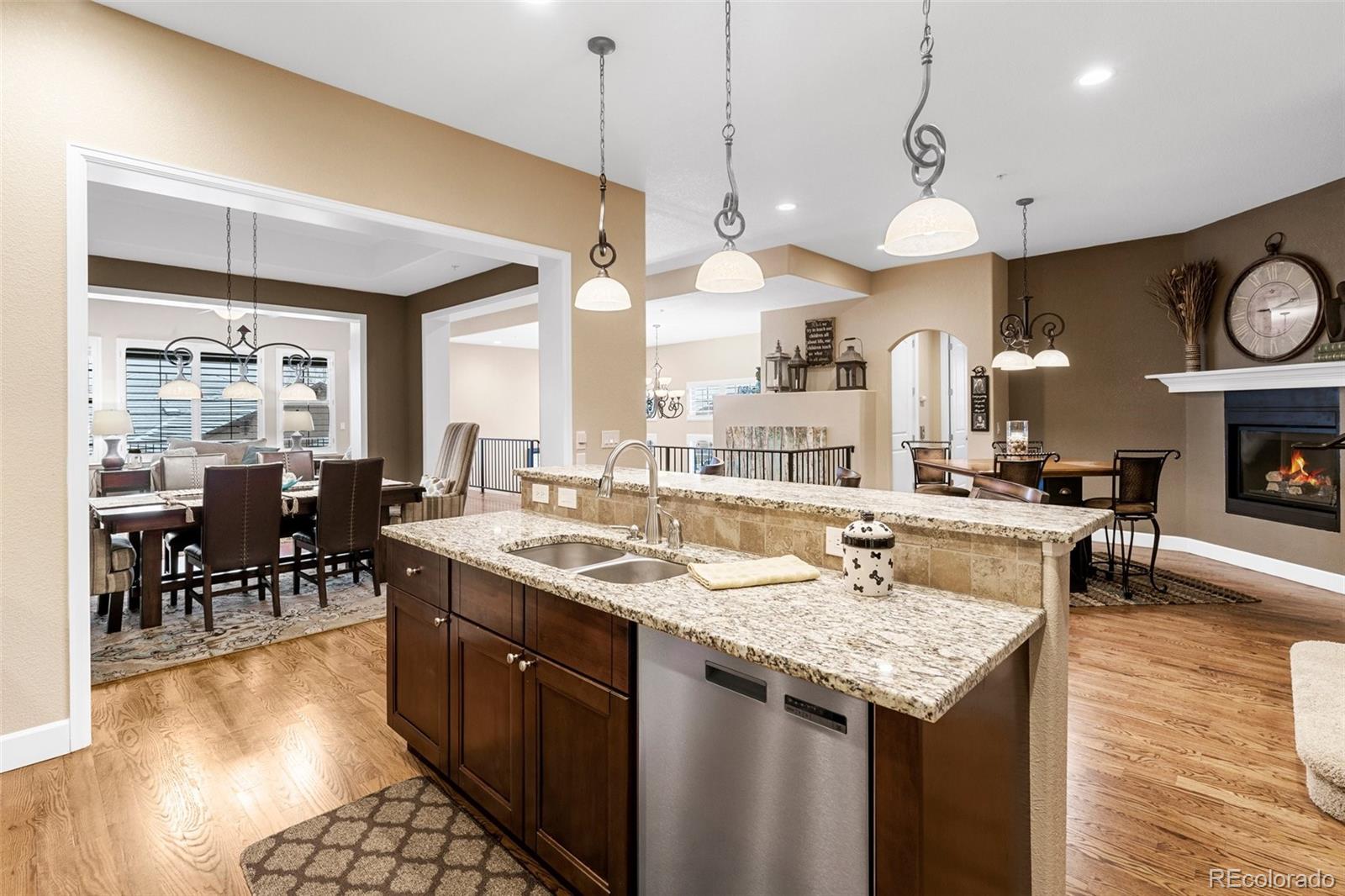 4315 Chateau Ridge Road Castle Rock, CO 80108 - Photo 11 of 26 a open kitchen with stainless steel appliances granite countertop a sink a stove and a wooden floors