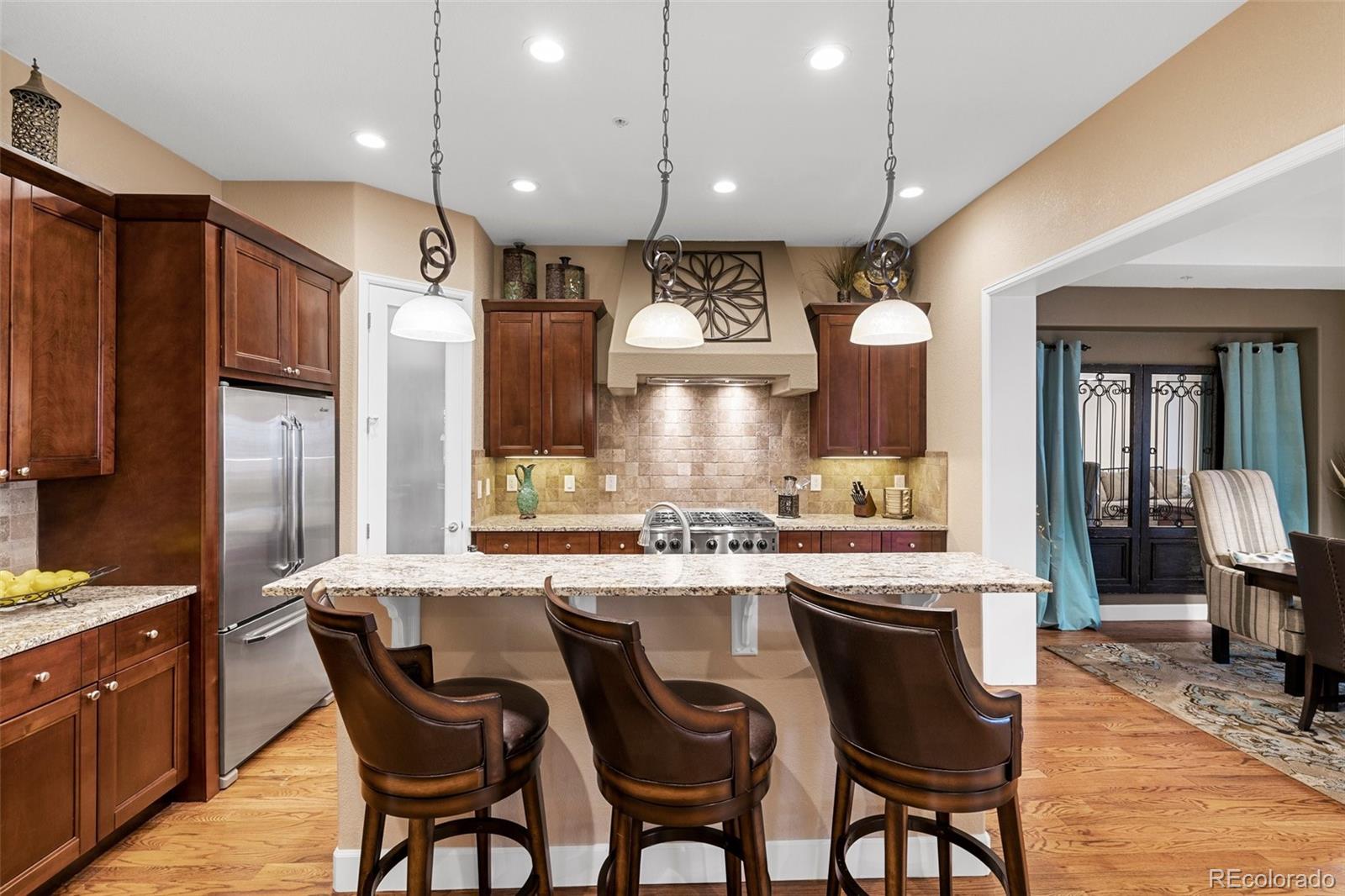 4315 Chateau Ridge Road Castle Rock, CO 80108 - Photo 9 of 26 a kitchen with stainless steel appliances kitchen island granite countertop a sink refrigerator and cabinets