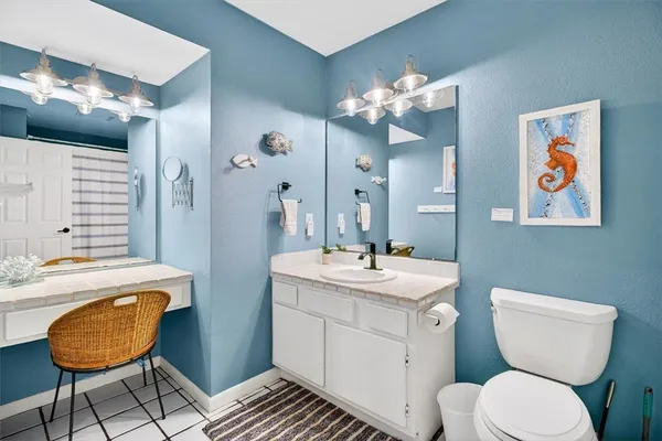 a bathroom with a granite countertop toilet a sink a mirror and bathtub